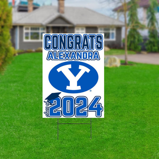 A 18 by 24 inch BYU Customized Yard Sign  staked in a lawn in front of a house.