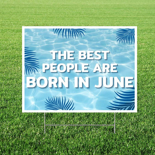 Garden sign with pool design and text 'The best people are born in June' on grass.