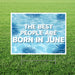 Garden sign with pool design and text 'The best people are born in June' on grass.