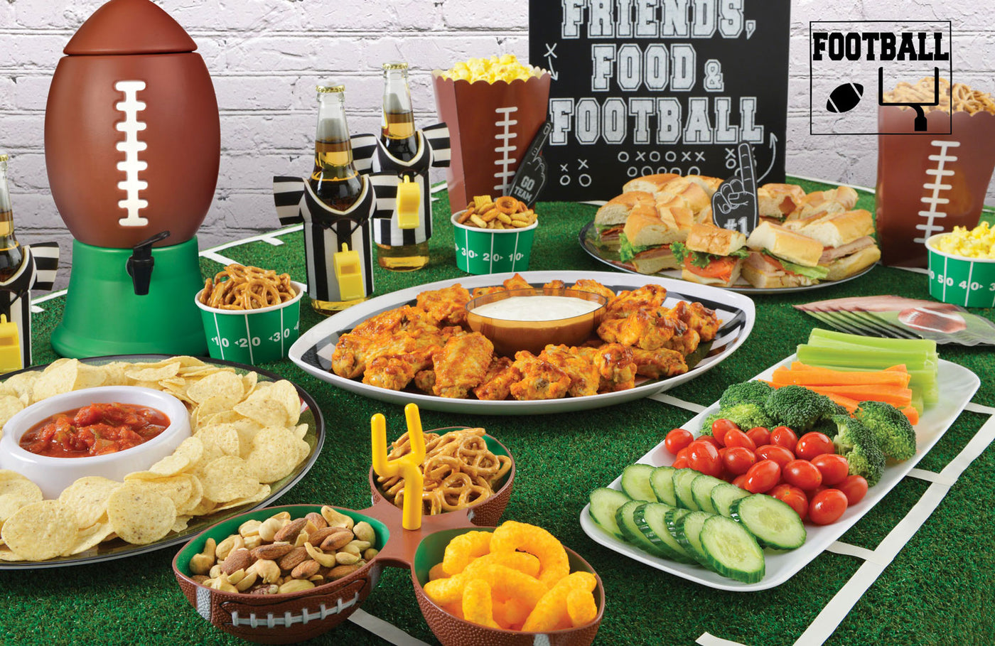 Pic of a table setting for a football party.  The table setting features various football themes table and serving ware with logs of different snacks.  This Table is ready for the big football game party.
