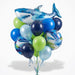 Shark birthday balloon bouquet featuring a large blue shark-shaped foil balloon, two round “Happy Birthday” shark foil balloons, and navy, blue, light blue, and lime green latex balloons with curling ribbons.