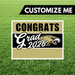 Graduation-themed sign with 'Congrats Grad 2026' on a grass background