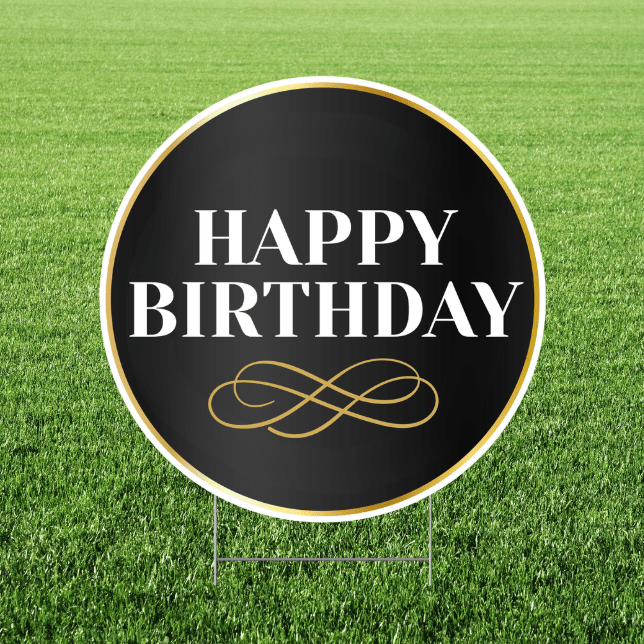 Round 'Happy Birthday' sign with decorative text on a grass background