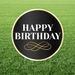 Round 'Happy Birthday' sign with decorative text on a grass background