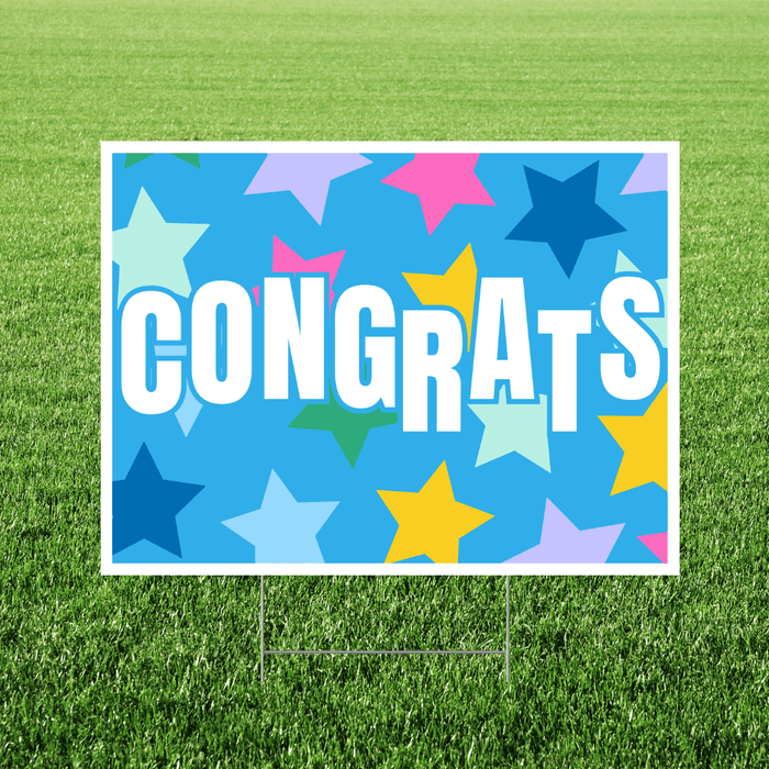 Congrats yard sign featuring a bright blue background with colorful star graphics, large white “Congrats” lettering with light blue shadowing, and a white rectangular border displayed in grass.