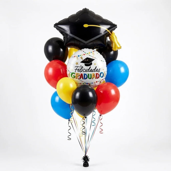 Spanish graduation balloon bouquet featuring a black graduation cap-shaped foil balloon, a round “Felicidades Graduado” foil balloon, and red, yellow, blue, and black latex balloons with curling ribbons.