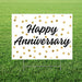 Happy anniversary yard sign featuring black script lettering on a white background with gold polka dots, displayed in grass.