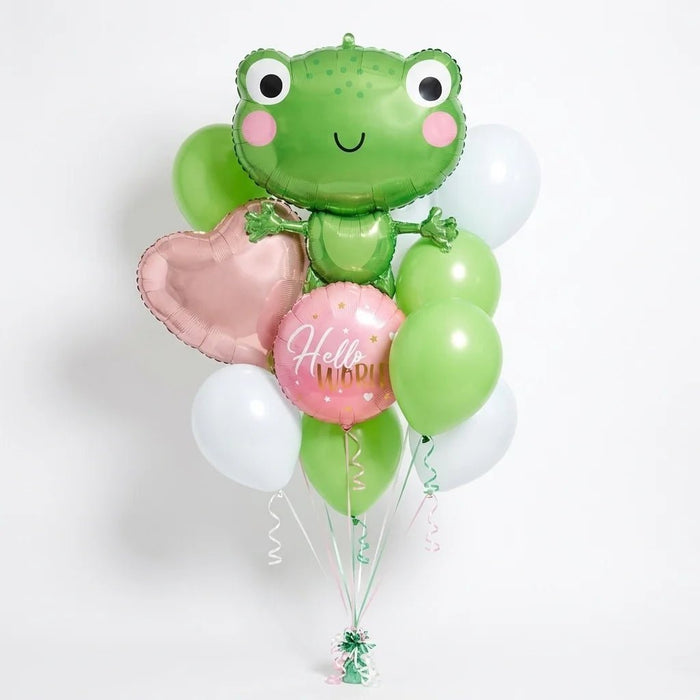 Baby balloon bouquet featuring a smiling frog-shaped foil balloon, a pink “Hello World!” foil balloon, a paste; pink heart-shaped foil balloon, and green and white latex balloons with curling ribbons.