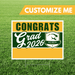 Graduation-themed sign with 'Congrats Grad 2026' on a grass background