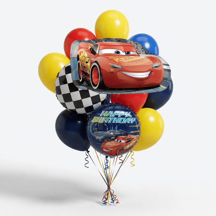 Lightning McQueen birthday balloon bouquet featuring a large race car foil balloon, a round “Happy Birthday” Cars balloon, a checkered flag balloon, and red, yellow, blue, and navy latex balloons with curling ribbons.