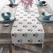 Table setting with a decorative table runner featuring Missouri state patterns on a wooden table.