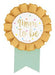 Mom-to-be award ribbon featuring a gold rosette with a white center that says “Mom to be” in gold script, plus mint green ribbon tails.