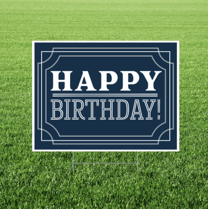 Navy “Happy Birthday” yard sign featuring white vintage-style lettering and decorative border lines on a rectangular sign displayed in grass.
