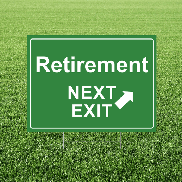 Retirement yard sign designed like a green highway exit sign, featuring white “Retirement” and “Next Exit” text with a white arrow, displayed in grass.